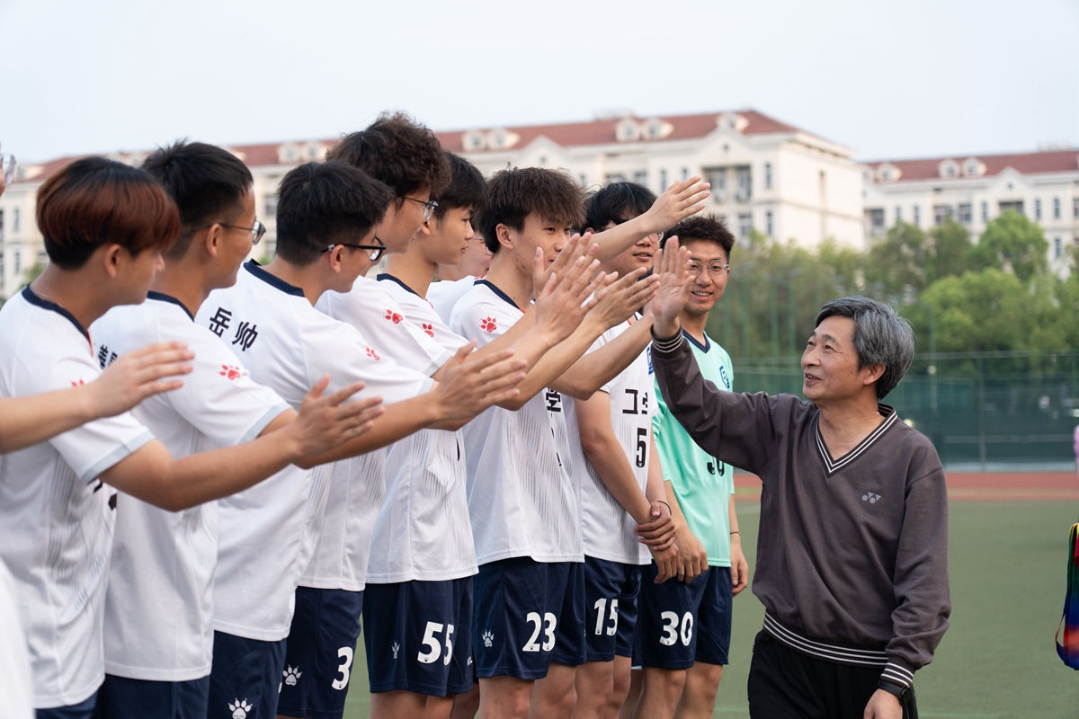 高翅书记与研究生男子组获奖球员击掌（学通社记者 韩鑫垚 摄）