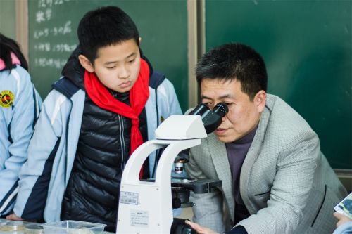 陈大松老师为同学们调试显微镜进行观察（学通社记者 彭雨格 摄）