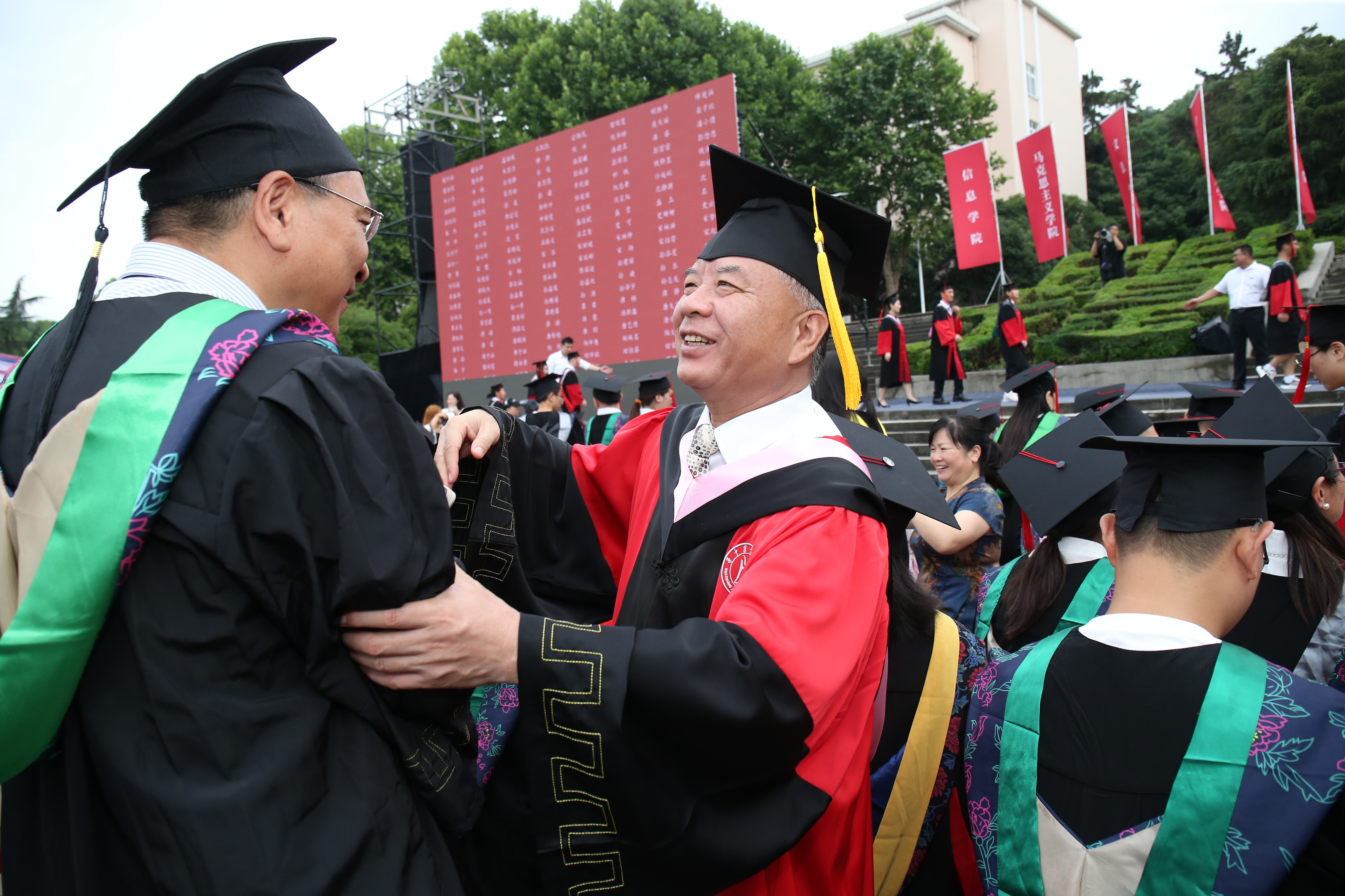 6月23日，华中农业大学毕业典礼暨学位授予仪式现场，校党委副书记、副校长姚江林在“125校友专区”为1988届校友王海生行拨穗礼（徐行 摄）