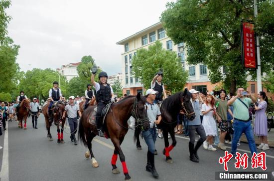 动科动医学院毕业生骑着马匹参加巡游（中新社记者 张畅 摄）