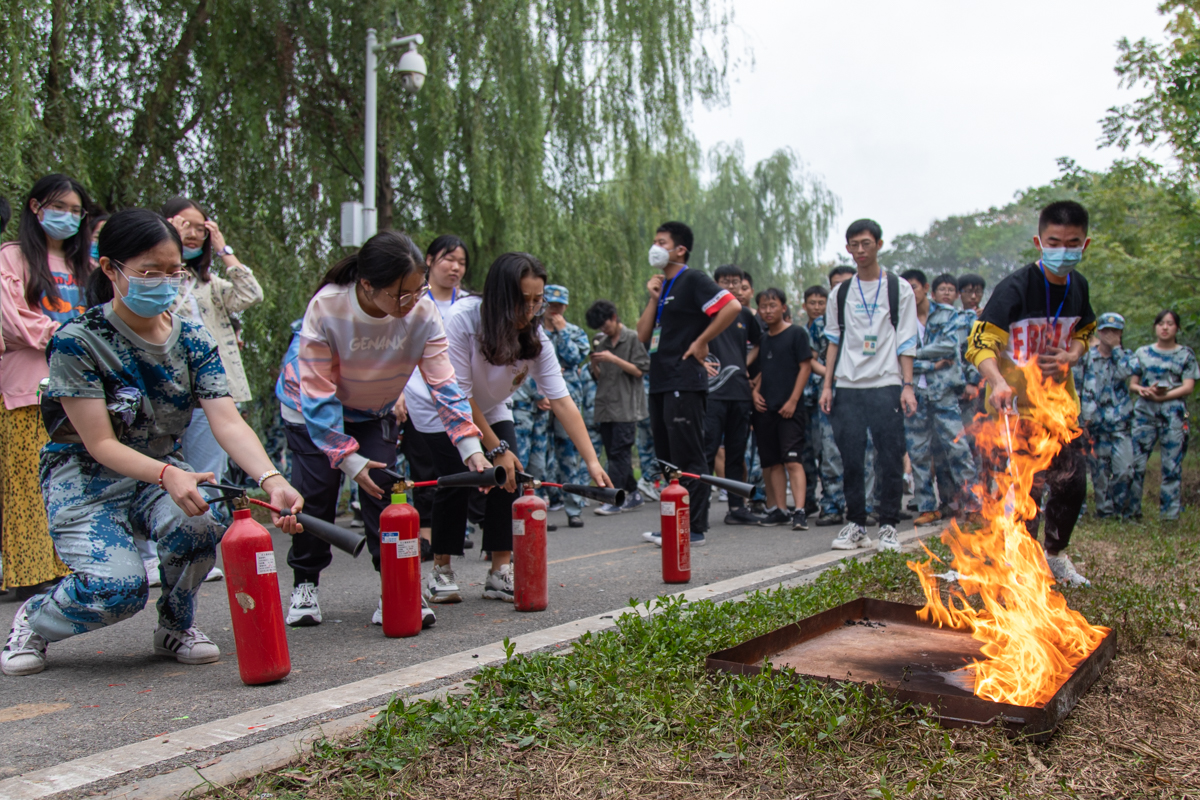 指导人员点火后，新生准备使用灭火器（学通社记者 欧嘉怡 摄）