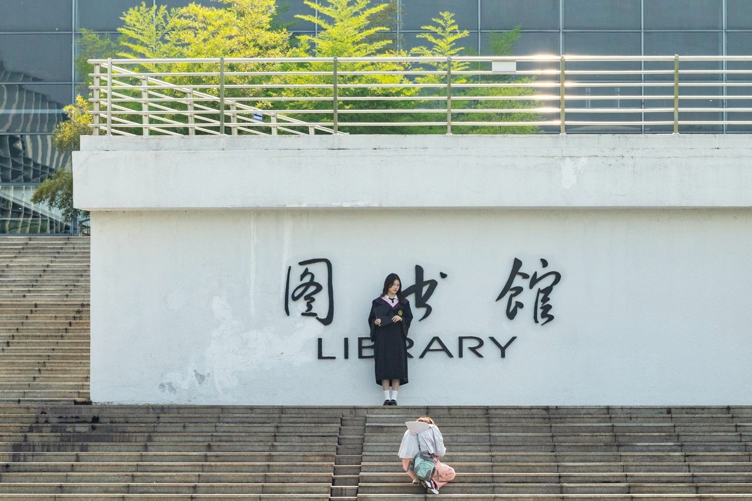 一名毕业学子正在图书馆前拍照（学通社记者 程希怡 摄）_副本