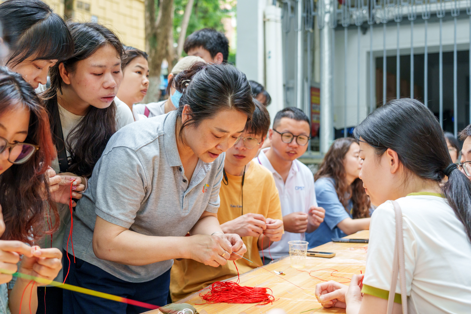 楼管阿姨教同学们编五彩绳（学通社记者 韩鑫垚 摄）