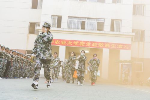 2018新生消防安全演习，火情警报后，参与演习的同学从着火楼栋里以湿毛巾掩鼻跑出（学通社记者 彭韵菲 摄）