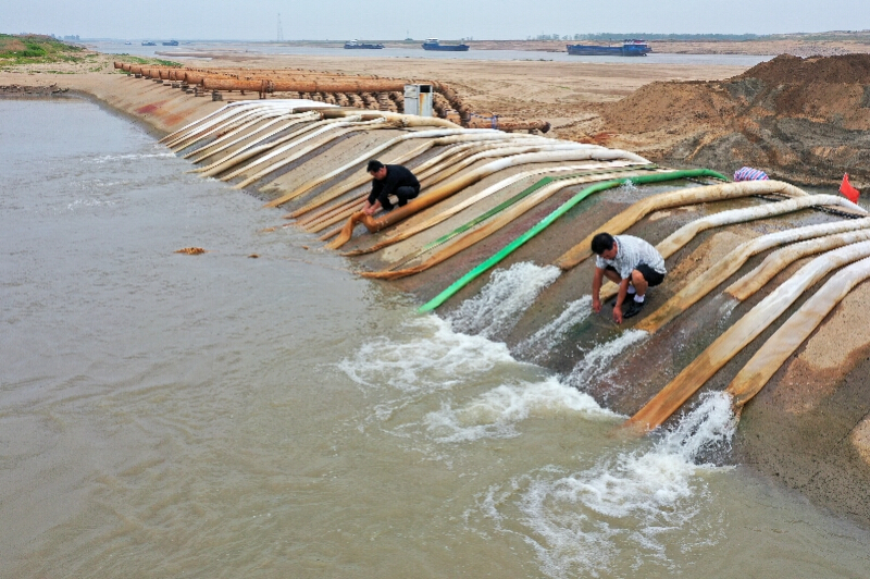 鄱阳湖畔多举措供水抗旱，保障粮食生产。9月8日，在鄱阳湖畔的南昌市新建区铁河乡一电排站，工作人员从外河引水渠抽水灌溉农田（无人机照片）。 新华社发