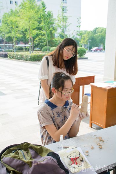 观众认真的观看着参赛选手泥塑过程