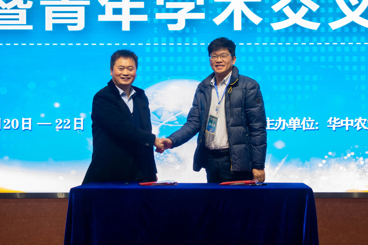 研讨会开幕式签约代表握手(学通社记者 邓颖骏 摄)