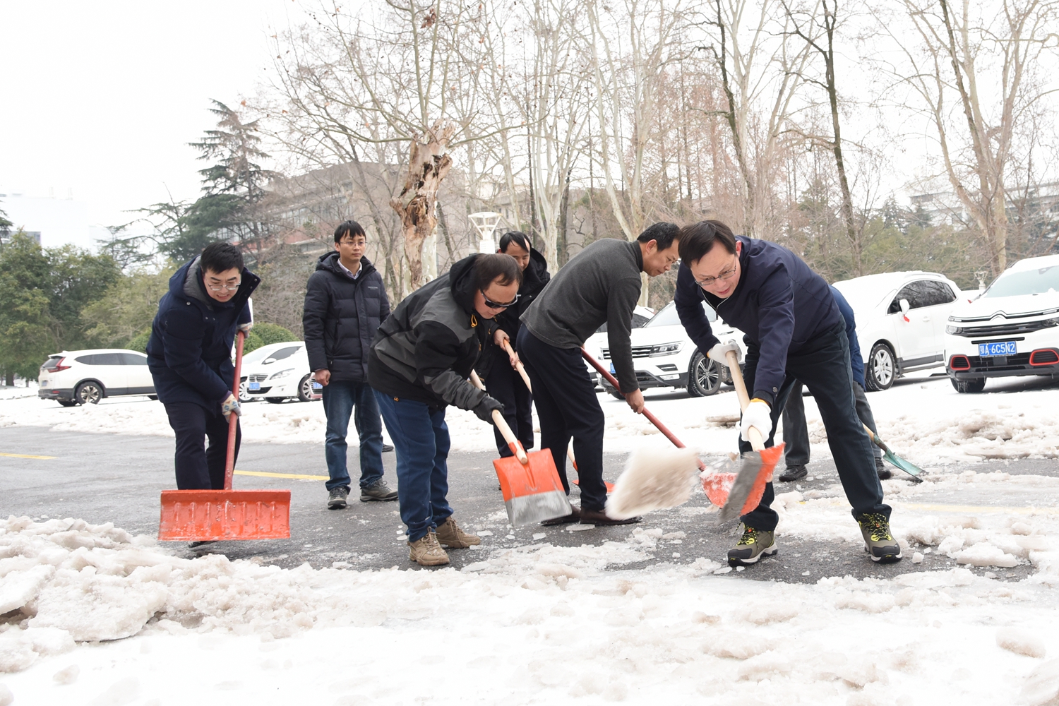 副校长王建鸿、杨少波等与机关干部除雪(蒋朝常 摄)