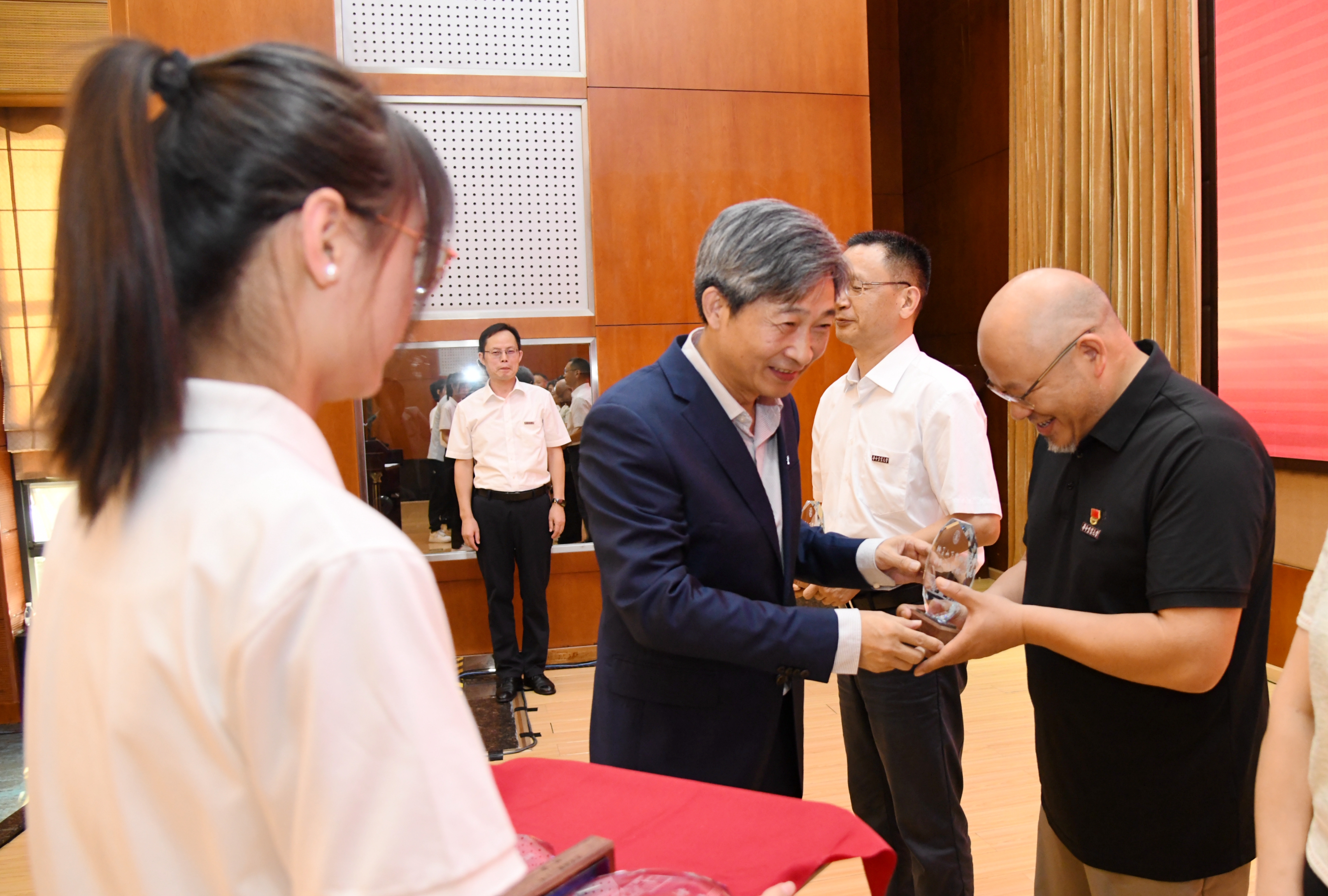 校党委书记高翅为从教30年教师代表颁发纪念牌(记者 徐行 摄)