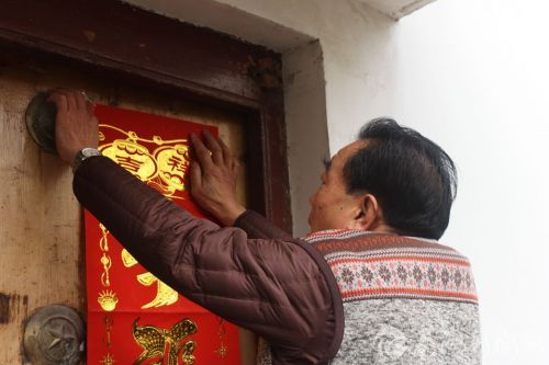 贴春联是过年必做的事情,老人家总是亲力亲为。