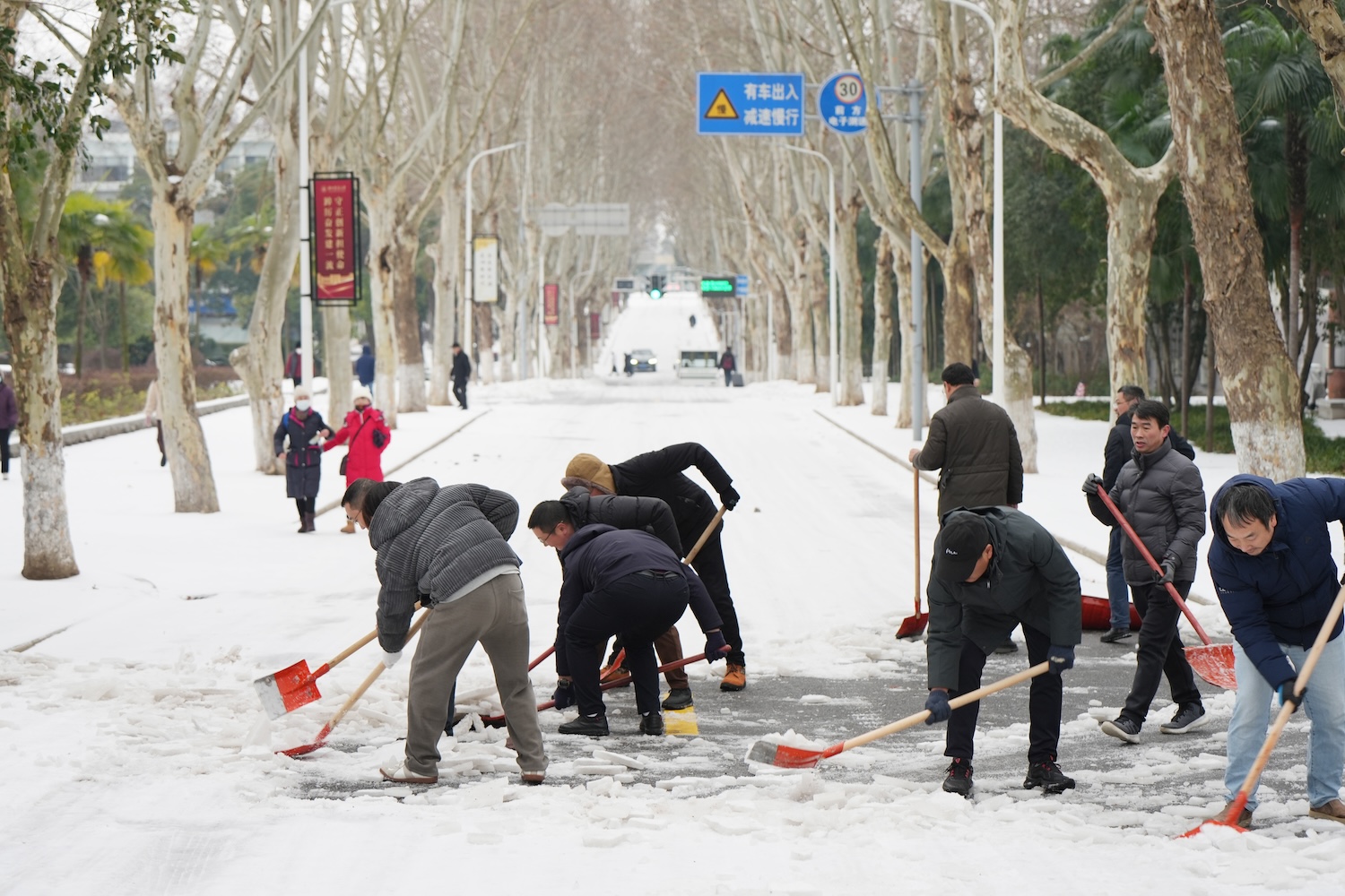 清理学院路上的积雪（记者 晏华华 摄）