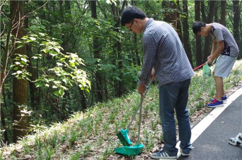 同学们带着工具上山打扫卫生