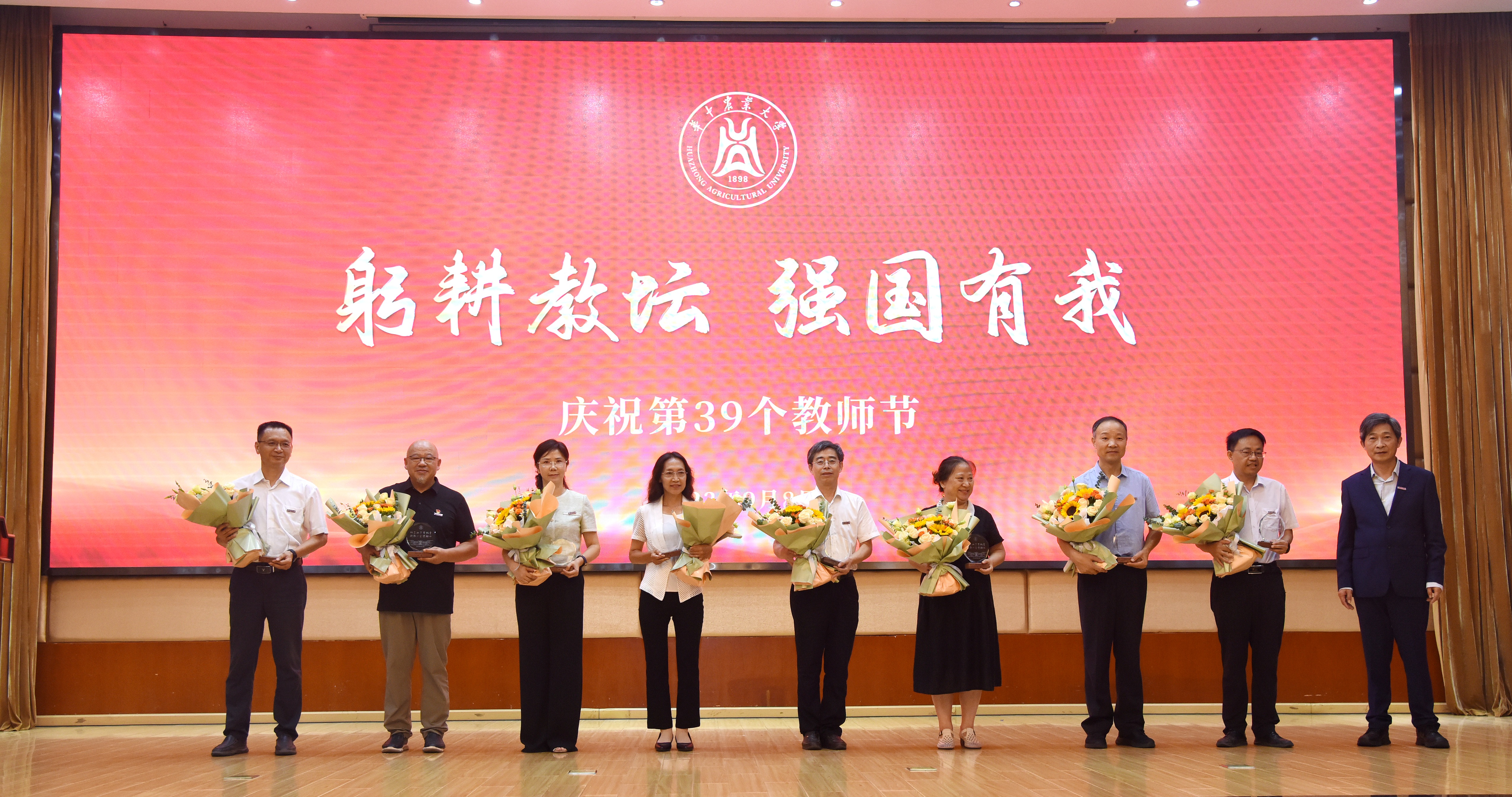 高翅与光荣从教30年教师代表合影留念(记者 匡敏 摄)