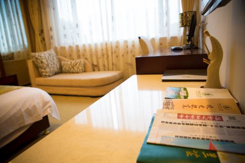 图四：客房内放有华农校报、校史概览、《狮山兰芷》等华农宣传资料