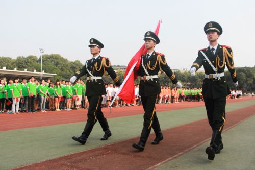 在同学们的注目下,国旗护卫队进行交旗