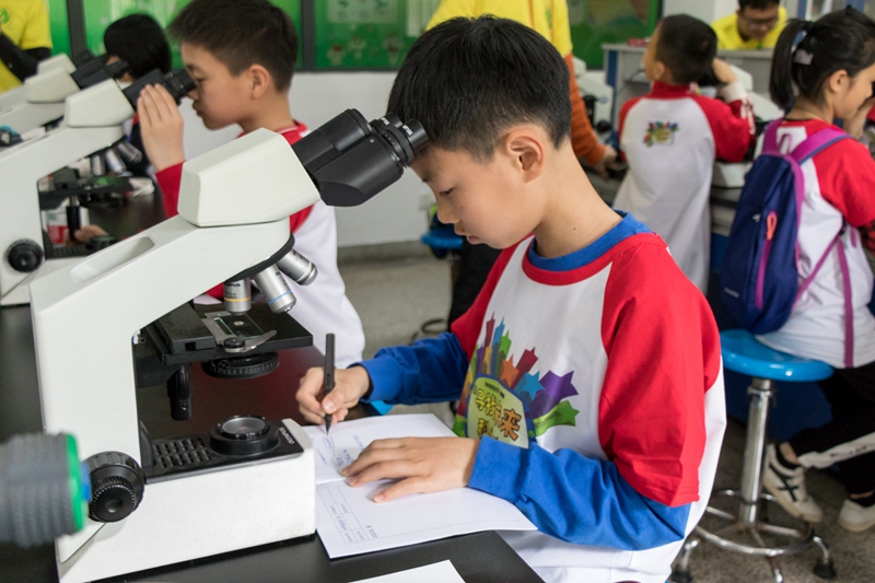 4月13日,第一综合楼,未来科学家班开班典礼后,一位小朋友在实验完成后认真做笔记【学通社记者 黎晨聪 摄】