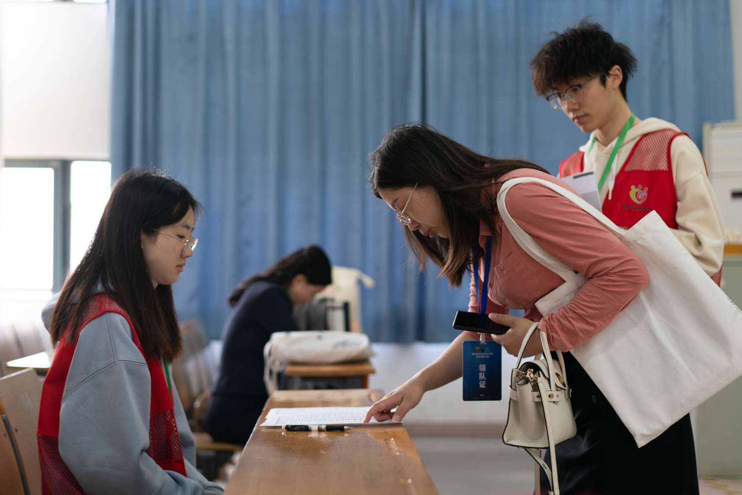 志愿者在候场区为参赛教师服务(学通社记者 郦雪怡 摄)