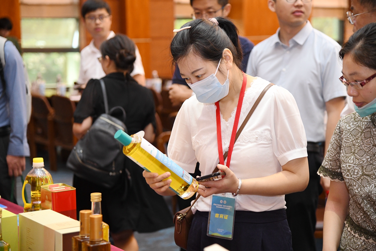 16 与会嘉宾观看高油酸菜籽油(通讯员 徐行 摄)