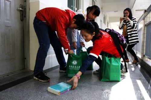 同学们帮志愿者姐姐装好捐赠的书籍