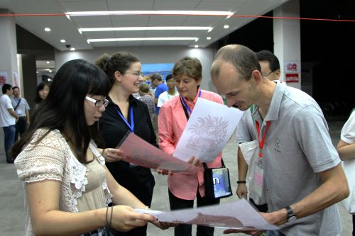 剧场外“品味中国传统文化”上,向外国友人展示剪纸