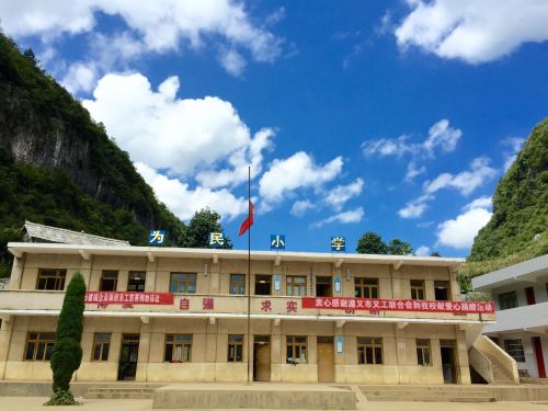 为民小学正面图，蓝天掩映时，也是很美的，只是这栋教学楼还是破旧、落后的